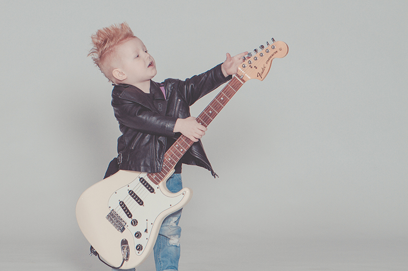 a child holding an electric guitar